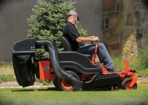 Man riding lawn mower with bagger in the back