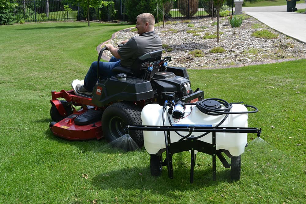 Man using his lawn mower with ironton trailer kit