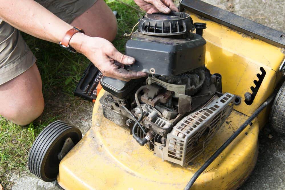 Man pull out his lawn mower carburetor