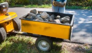 Lawn tractor towing cart full of stone