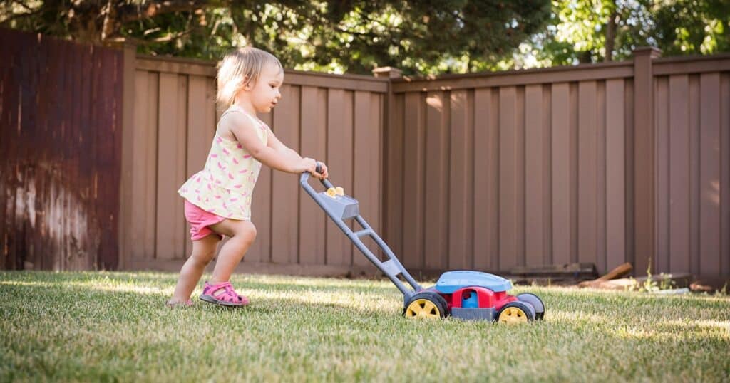Kids playing her lawn mower toy