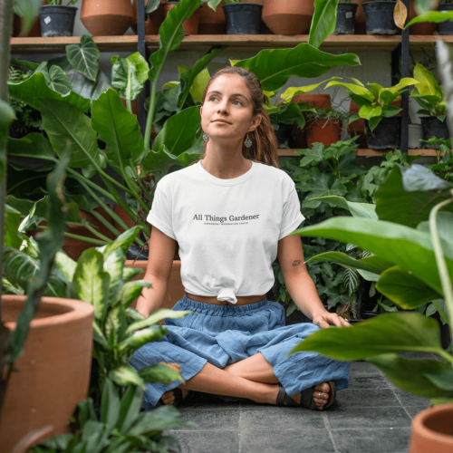 T-shirt-mockup-of-a-relaxed-young-woman-sitting-in-a-greenhouse-27084